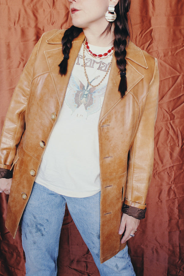 Women's or men's vintage 1970's Lou Pollack, Made in Spain label long sleeve long length tan camel brown colored leather blazer jacket with tortoise buttons up the front.