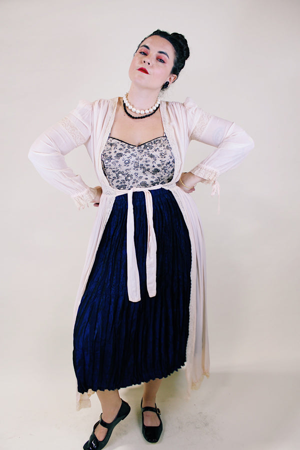 Women's vintage long sleeve long length pale pink sheer robe with an open tie front and lace trim. Has small shoulder pads and ties on cuffs. 