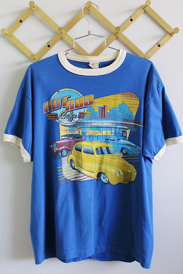 Women's or men's vintage 1970's made in USA blue short sleeve t-shirt with white ribbed trim and large Hot Rod Cafe graphic on the front.