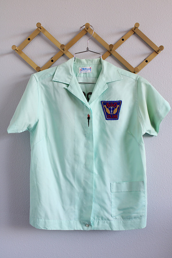 Women's vintage 1960's Hilton, Made in USA label short sleeve teal colored cotton button up blouse with collar and front pocket.