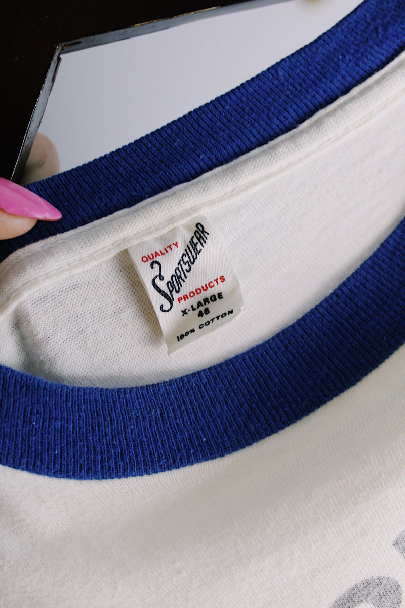 Men's or women's vintage 1970's Quality Sportswear Products, Made in USA label white ringer tee with blue trim and black graphic on the front. 