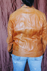 Women's or men's vintage 1970's Adler Leather MFG. CO., Made in California label long sleeve burnt orange leather jacket that zips up the front with side pockets and dagger collar.