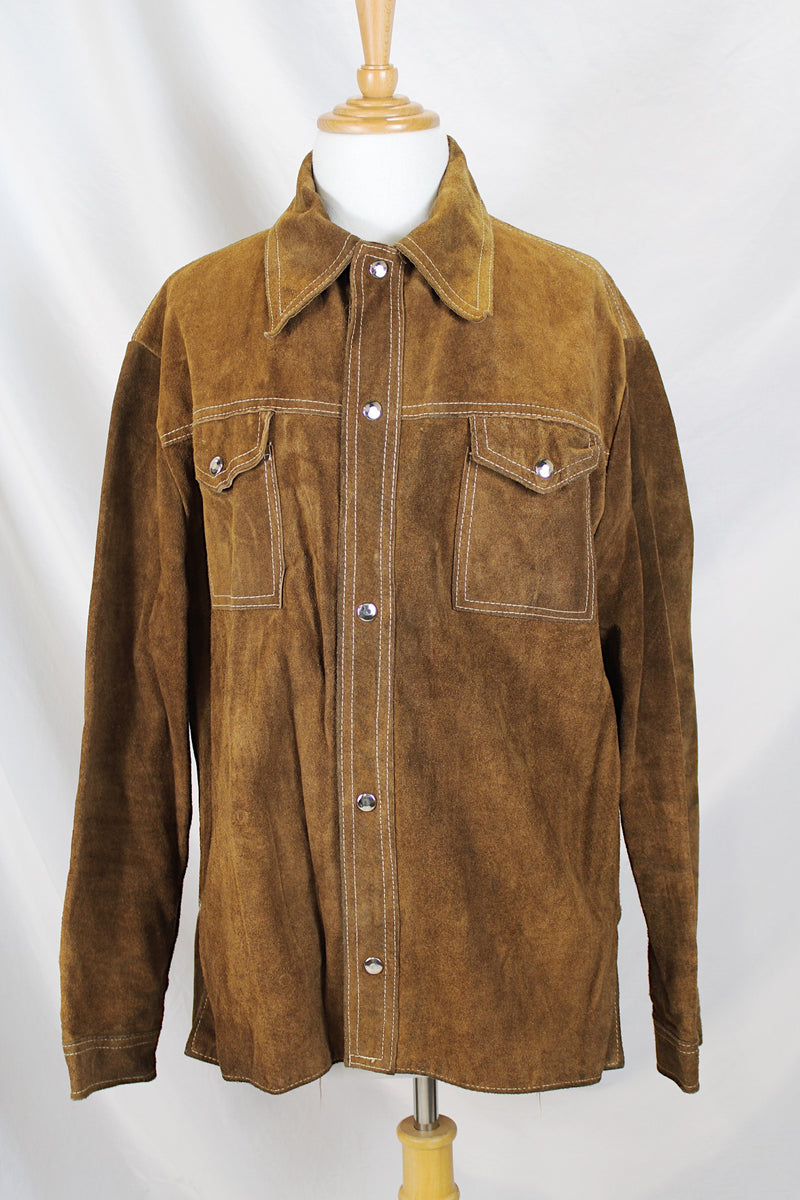 Men's or women's vintage 1970's long sleeve light brown tan colored suede jacket. Has silver snap buttons, contrast stitching, and a dagger collar.