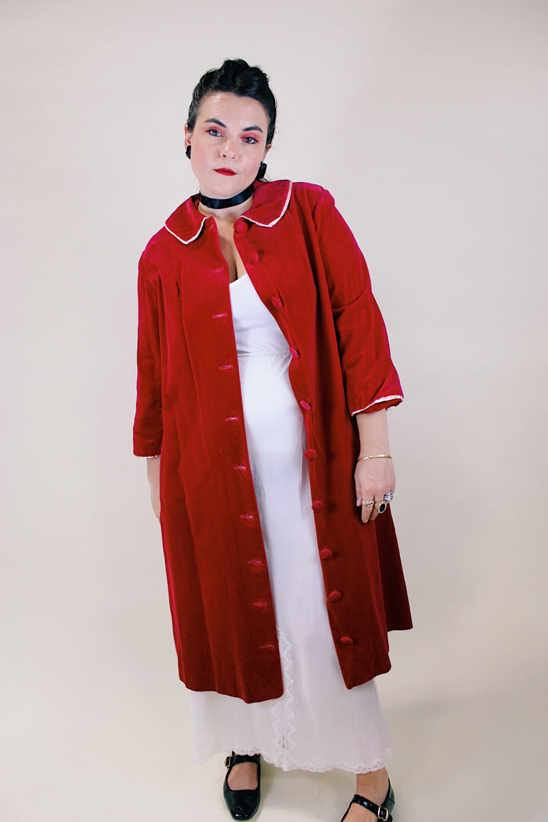 Women's vintage 1960's long length long sleeved red velvet robe duster with a peter pan collar and pink stain trim. Buttons up the front.