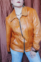 Women's or men's vintage 1970's Adler Leather MFG. CO., Made in California label long sleeve burnt orange leather jacket that zips up the front with side pockets and dagger collar.