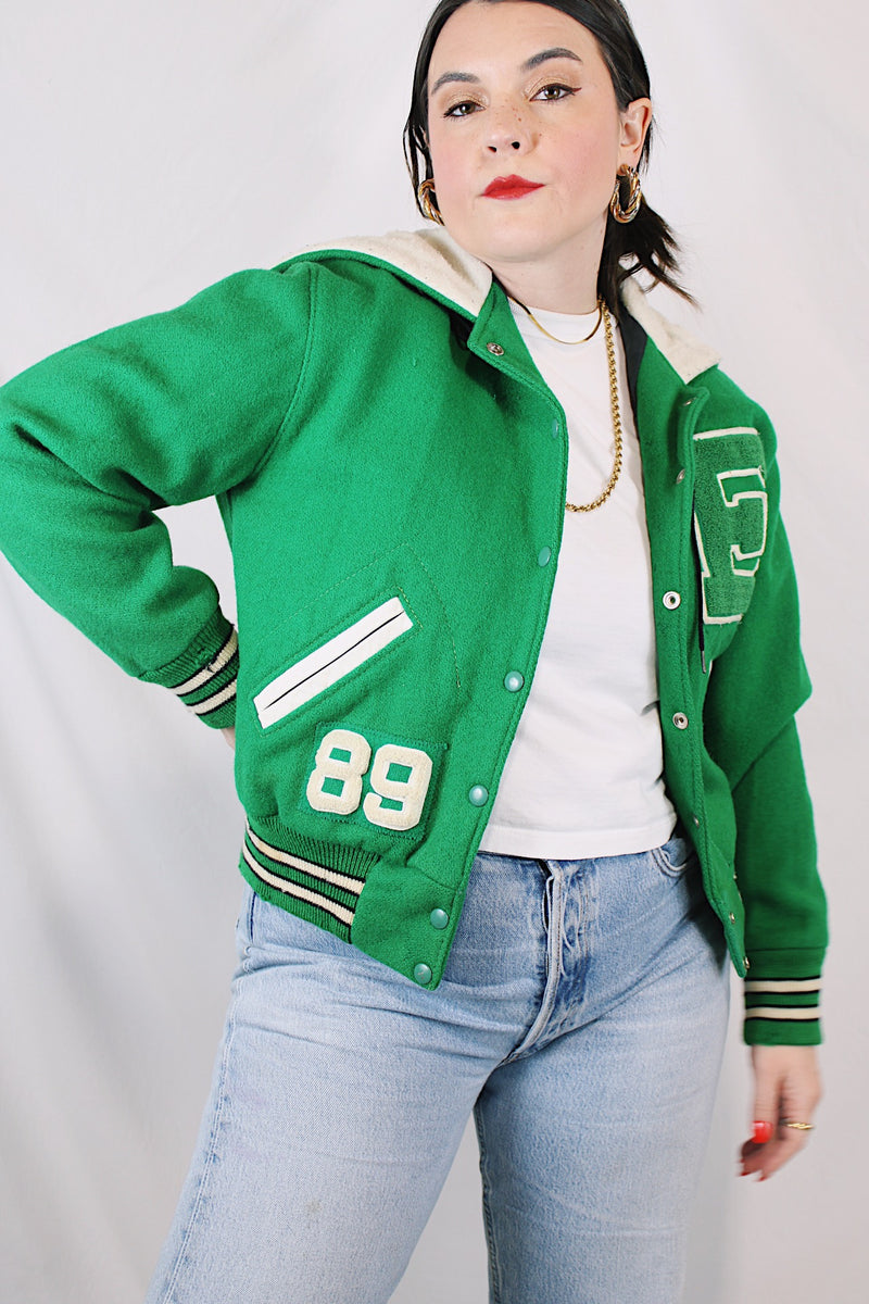 Women's vintage 1989 Nelson's Jacket, Portland, Oregon label bright green wool varsity letterman jacket with white trim. Has snap buttons, patches, pockets, and a hood. Shop more vintage outerwear and sportswear at Live Forever Vintage. 