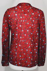 Women's vintage 1970's Donnkenny label long sleeve button up blouse with an attached tie neck. Red with all over blue ditsy floral print. 