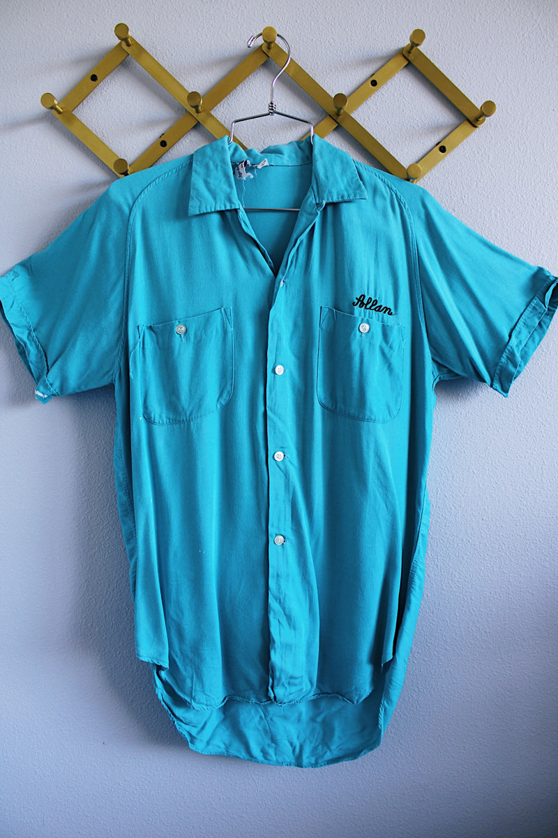 Men's or women's vintage 1970's The Swingster label short sleeve bright blue button up bowling shirt with chest pockets and name embroidered near pocket. 