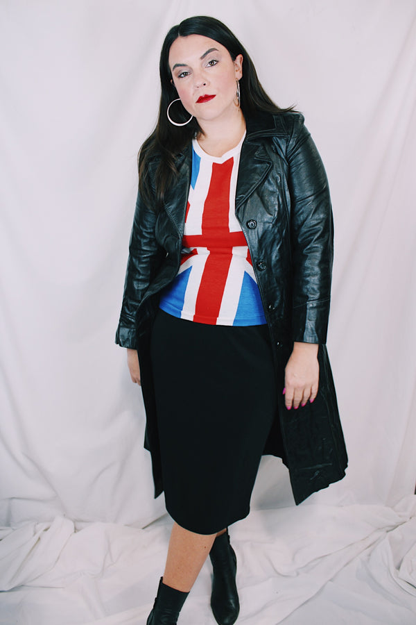 Women's vintage 1970's knee length long sleeve black leather trench coat with double lapel and button front closure. 