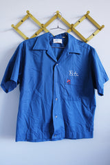 Men's or women's vintage 1970's Hilton label short sleeve blue button up bowling shirt with embroidered name and bowling pin. Wording on the back.