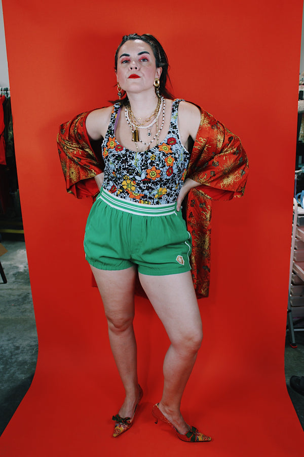 Women's vintage 1960's sleeveless one piece floral printed swimsuit in grey, black, and orange