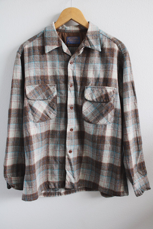 Men's vintage 1960's Pendleton size large long sleeve button up wool shirt in all over brown and blue plaid print. Two chest pockets. 