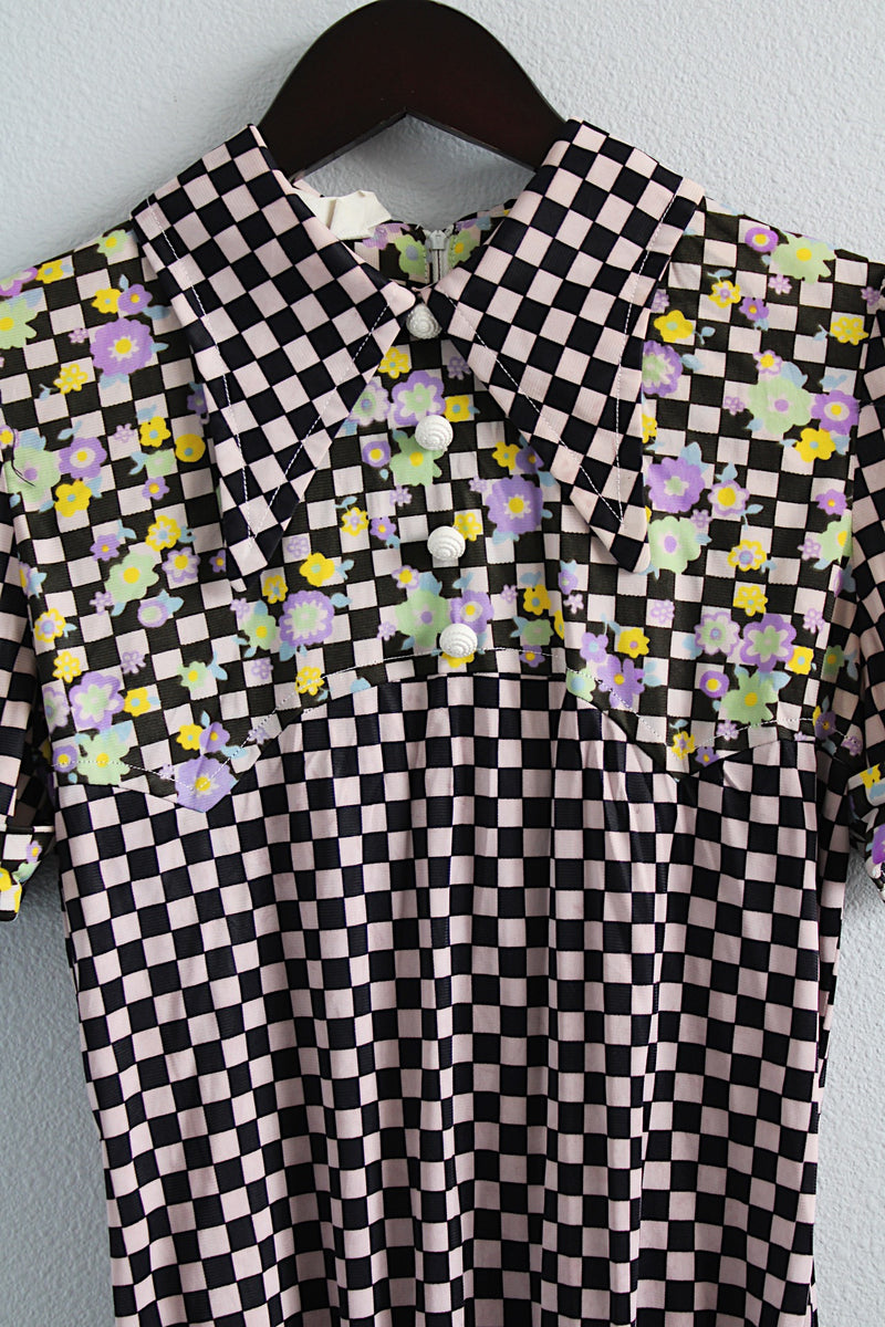 Women's vintage 1970's short sleeve puff sleeve bodysuit with collar in a black and purple checkered print and florals. 