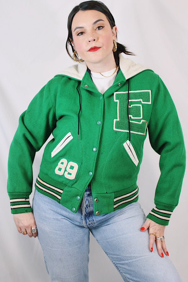 Women's vintage 1989 Nelson's Jacket, Portland, Oregon label bright green wool varsity letterman jacket with white trim. Has snap buttons, patches, pockets, and a hood. Shop more vintage outerwear and sportswear at Live Forever Vintage. 