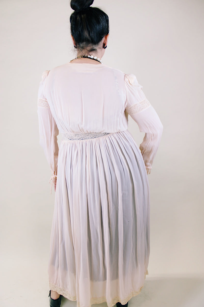 Women's vintage long sleeve long length pale pink sheer robe with an open tie front and lace trim. Has small shoulder pads and ties on cuffs. 