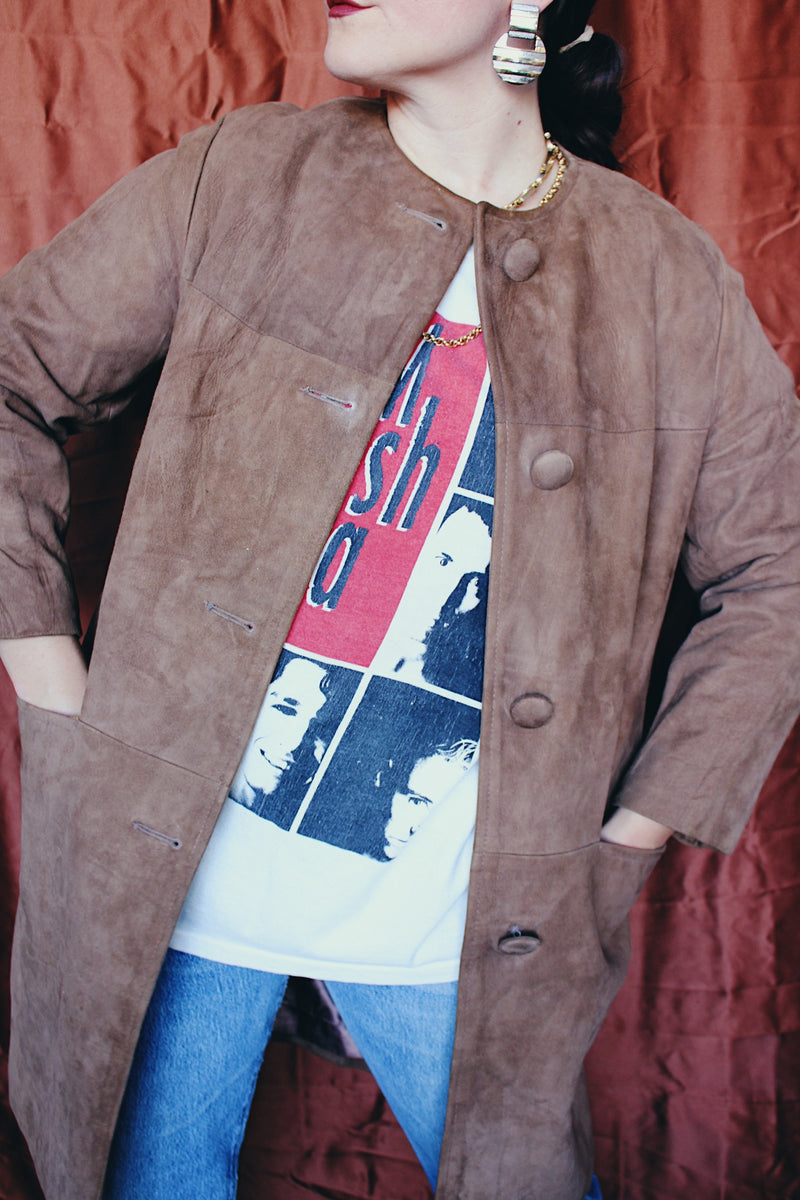 Women's vintage 1960's long length long sleeve tan brown colored suede jacket. No collar and suede buttons up the front.