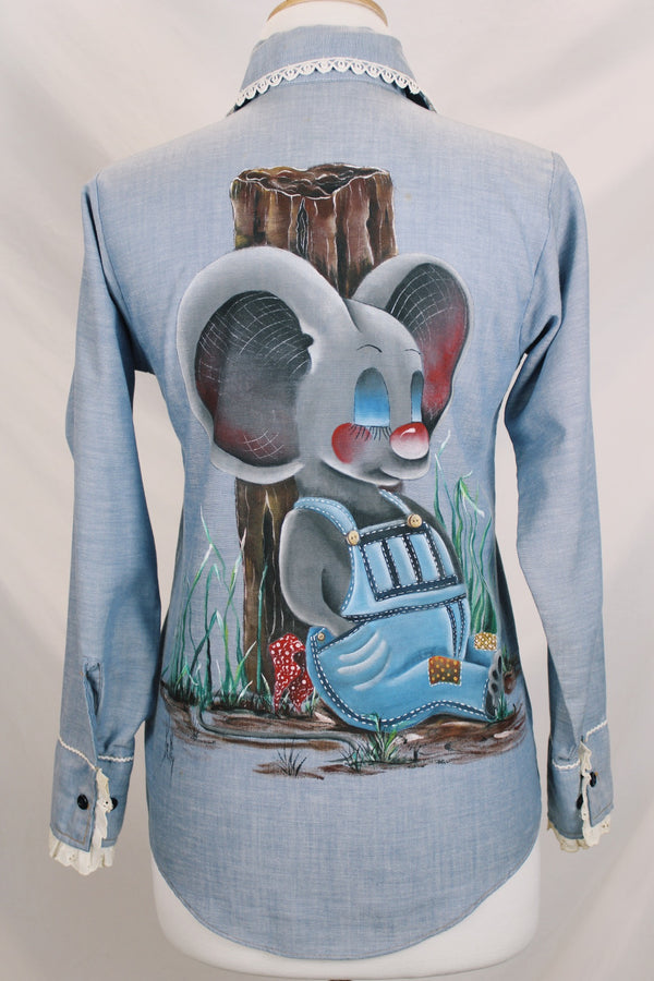 Women's vintage 1970's JCPenney Plain Pockets label long sleeve light blue chambray denim button up top with white applique trim and large graphic of mouse on back