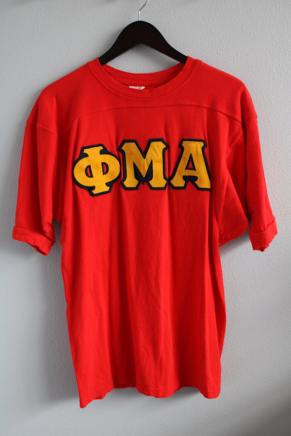 Women's or men's vintage 1970's short sleeve bright red sport jersey with yellow patch lettering on the front. 