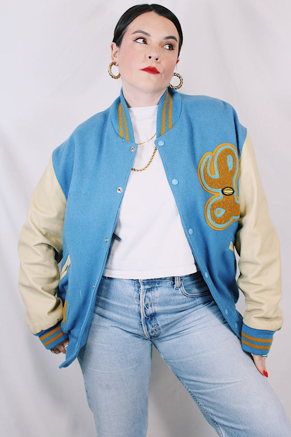 Men's or women's vintage 1994 Settlemien's, Portland, Oregon label long sleeve baby blue and cream varsity letterman jacket with yellow trim in leather and wool material. 