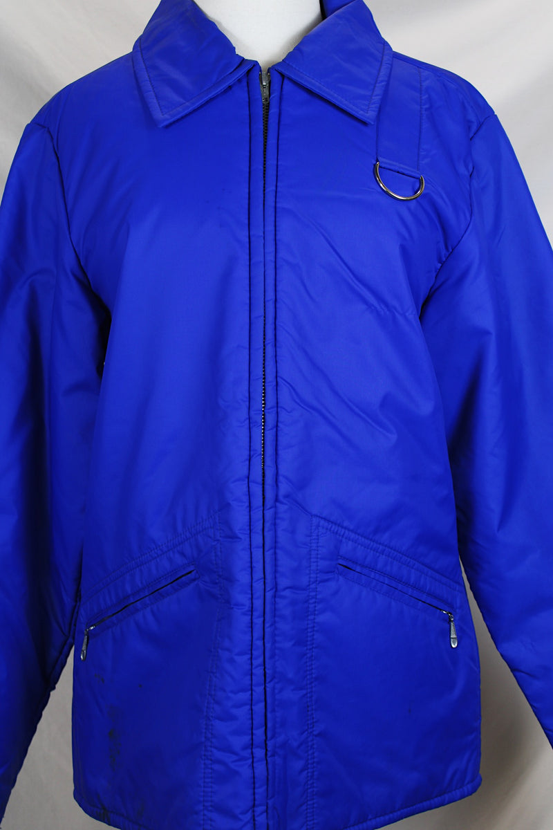 Men's or women's vintage 1980's Designer's Sportswear label long sleeve bright blue colored nylon material puffer jacket with side pockets.