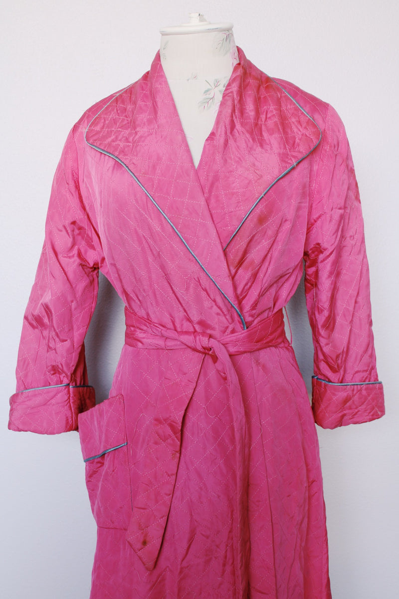 Women's vintage 1950's Lyn Delle label long sleeve long length bright pink quilted robe jacket with teal colored trim.