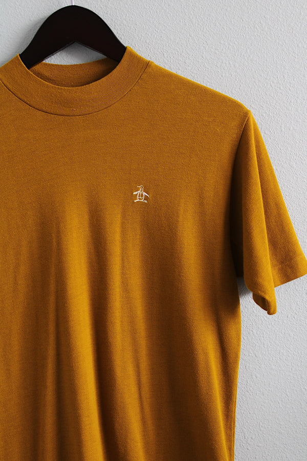 Women's or men's vintage 1980's Grand Slam by Munsingwear label short sleeve greenish brown tee with a small mock neck and penguin embroidery in a cotton and polyester material.