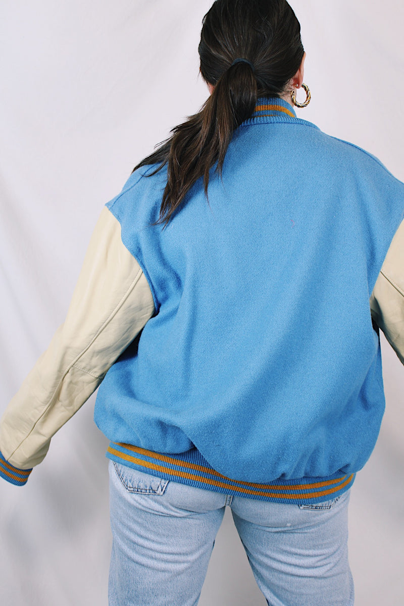 Men's or women's vintage 1994 Settlemien's, Portland, Oregon label long sleeve baby blue and cream varsity letterman jacket with yellow trim in leather and wool material. 