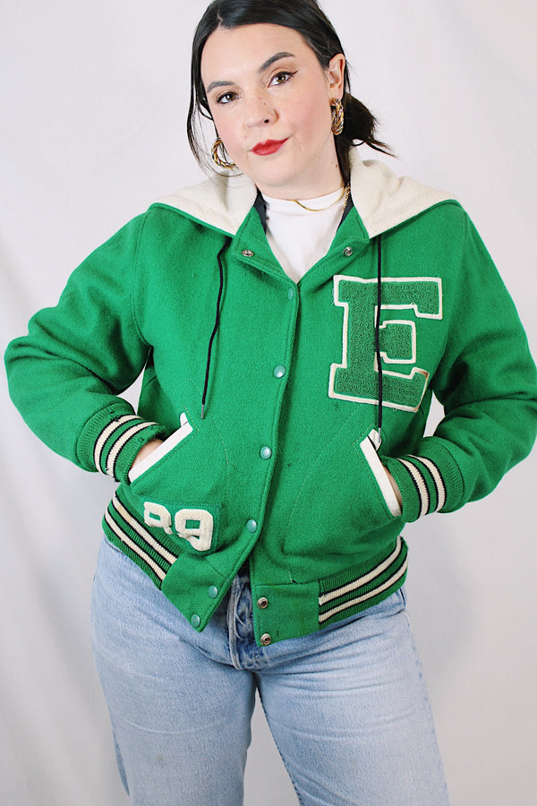 Women's vintage 1989 Nelson's Jacket, Portland, Oregon label bright green wool varsity letterman jacket with white trim. Has snap buttons, patches, pockets, and a hood. Shop more vintage outerwear and sportswear at Live Forever Vintage. 