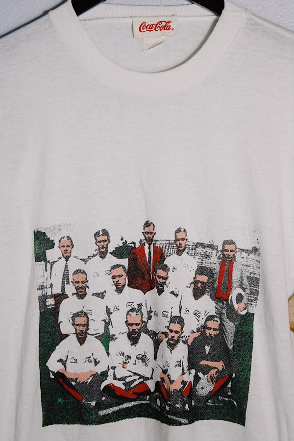 Women's or men's vintage 1986 Coca-Cola label short sleeve white tee with graphic on the front in a polyester and cotton material.