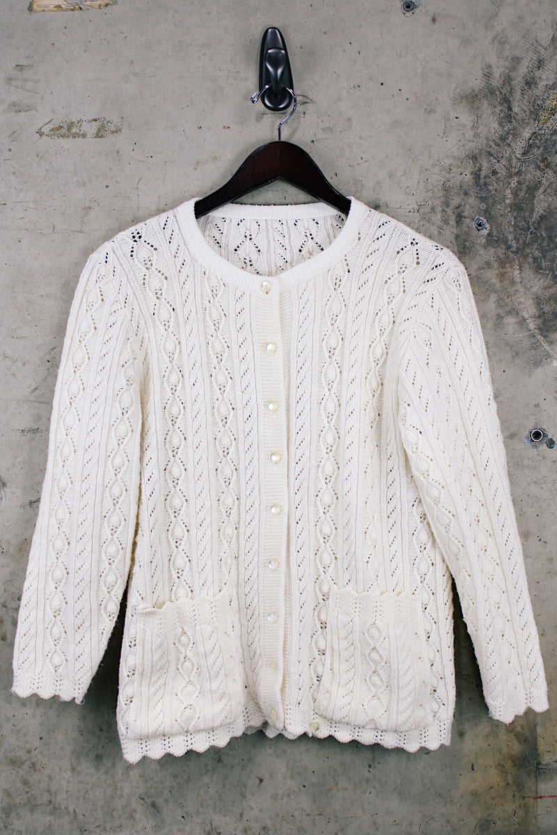Women's vintage 1970's long sleeve cream colored button up acrylic sweater with scalloped edges on hem and cuffs.