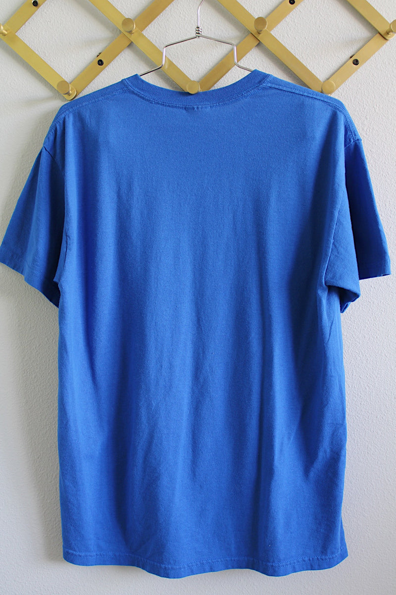 Women's or men's vintage 1990's short sleeve bright blue tee in size large in cotton material. Graphic on the front of Winston, Oregon high school mascot Winston Warriors.