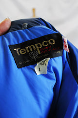 Women's vintage 1980's Tempco, Down Insulated, By Tempco Quilters Seattle, Made in USA label sleeveless navy and blue nylon puffy vest with popper buttons. 