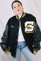 Men's or women's vintage 2000's Settlemein's, Portland, Oregon label long sleeve black varsity letterman jacket with yellow trim.