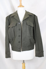 Women's or men's vintage cropped army jacket in a dark green grey wool material. Has a button closure and two front chest pockets. 