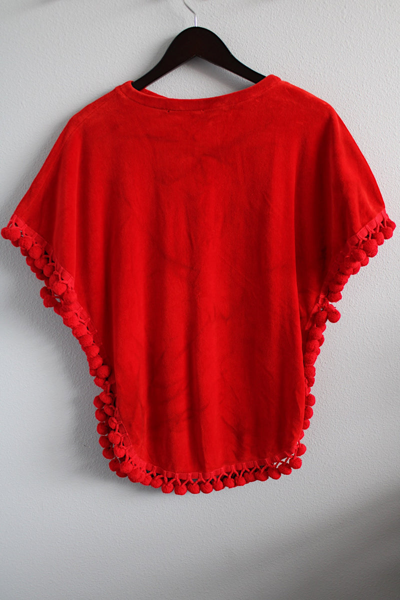 Women's vintage 1970's Aladdin label short sleeve red velour cape top with tasseled trim and holes for arms.