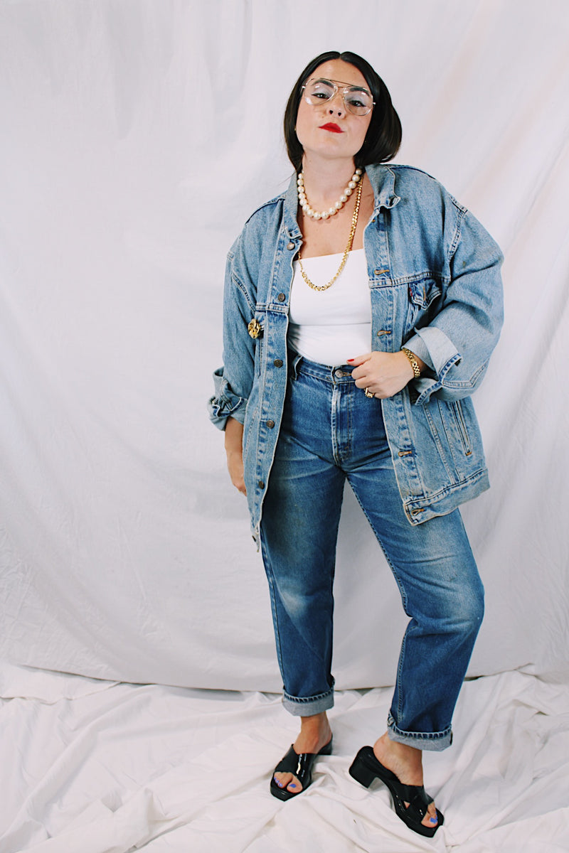 Men's or women's vintage 1980's Levi's medium wash denim lightweight jacket with brass hardware. Buttons up the front and four pockets. Size XXL.