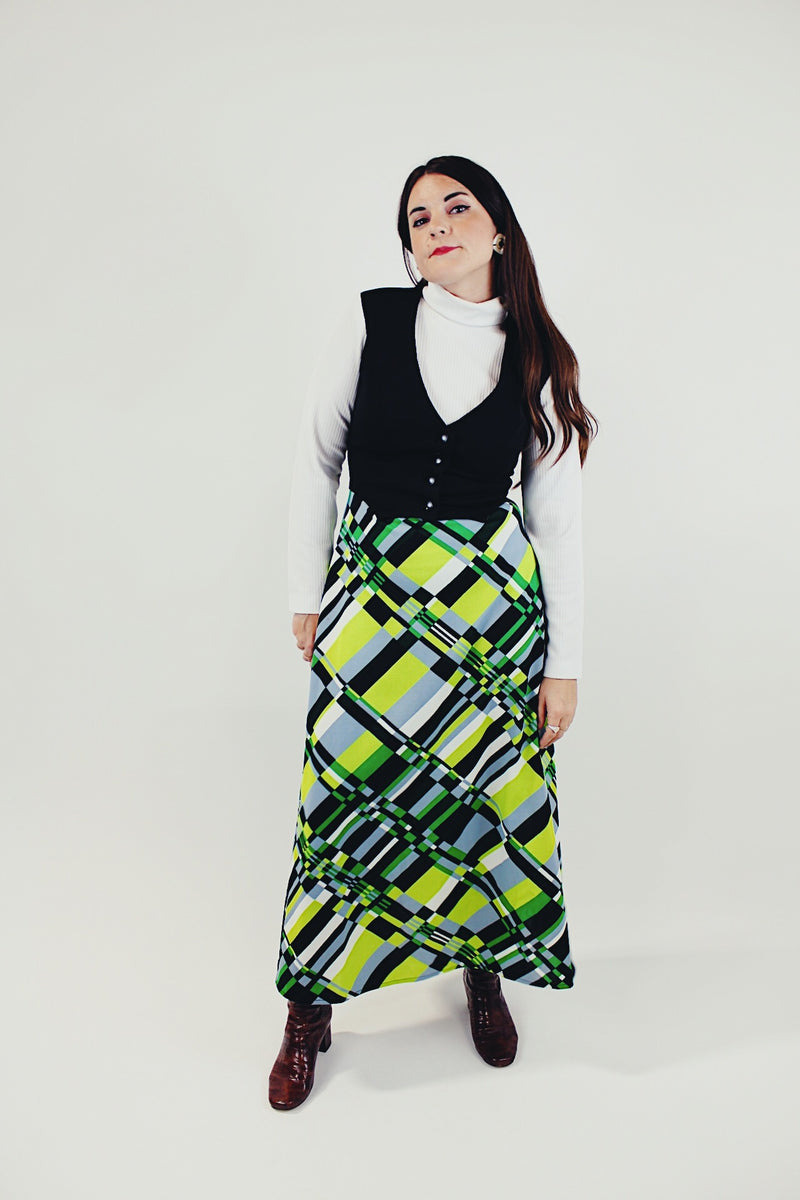 vintage long sleeve maxi dress with mock neck and attached black vest skirt bottom has green grey and black print front 