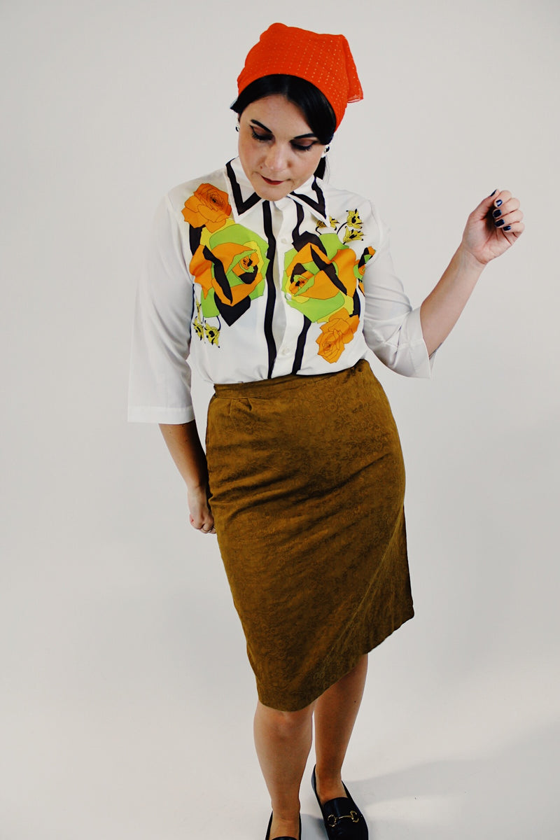 Vintage white button up blouse with green and orange flower print front tucked into skirt