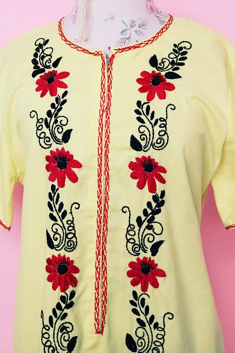 Women's vintage 1970's Wendy-Ann Inc. label short sleeve ankle length cotton material dress in bright yellow with all over red and black embroidered floral design.