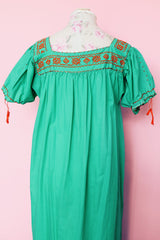 Women's vintage 1970's short sleeve cotton material green short sleeve ankle length dress with orange embroidery and a square neckline and puff sleeves.