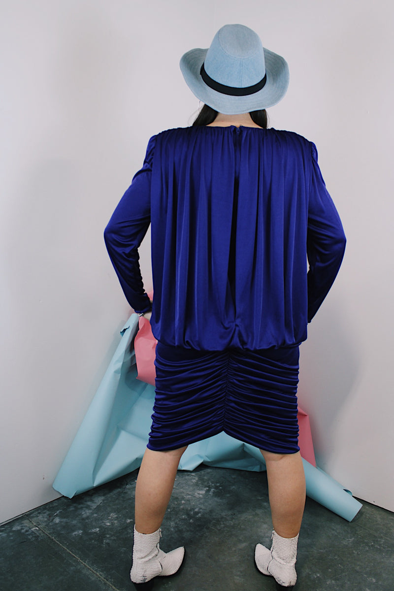 Women's vintage 1980's long sleeve knee length drapey purple slinky polyester dress with beaded trim neckline.