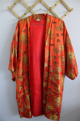 Women's vintage 1970's Made in Japan 3/4 arm length shiny satin like polyester open front kimono style robe with all over gold metallic print.