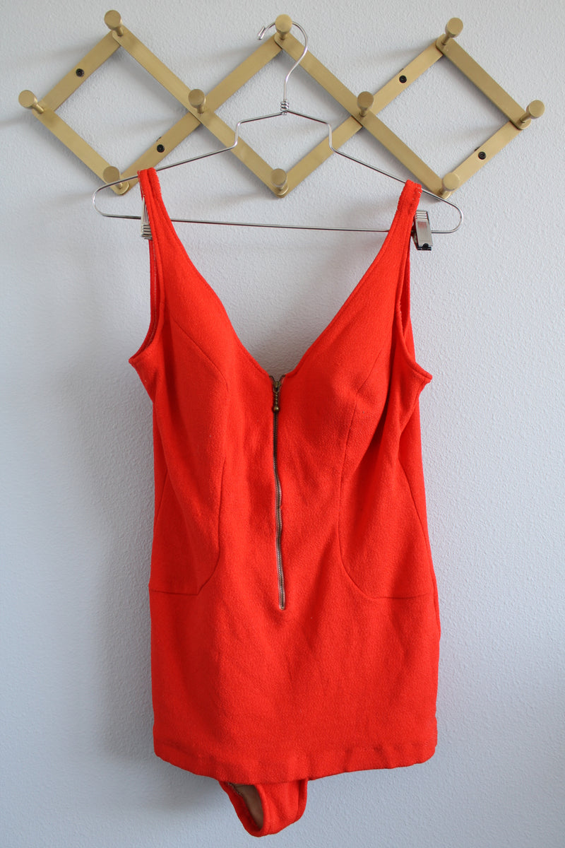 Women's vintage 1960's Catalina, California, USA label sleeveless one piece bright orange swimsuit with brass half zipper closure in the front.