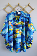 Women's vintage 1980's Made in Hawaii short sleeve wide cape blouse in all over blue Hawaiian print. 