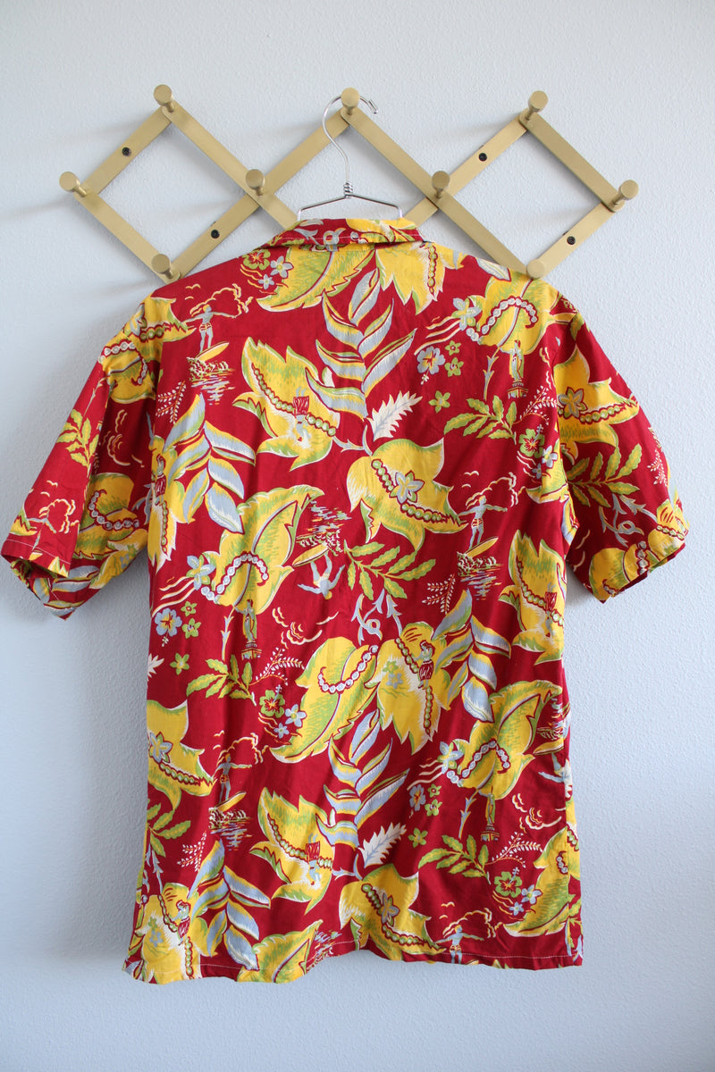 Women's or men's vintage 1970's Sundek, Made in USA label short sleeve button up shirt with dagger collar in cotton material with all over Hawaiian print in red, yellow, and green colors.