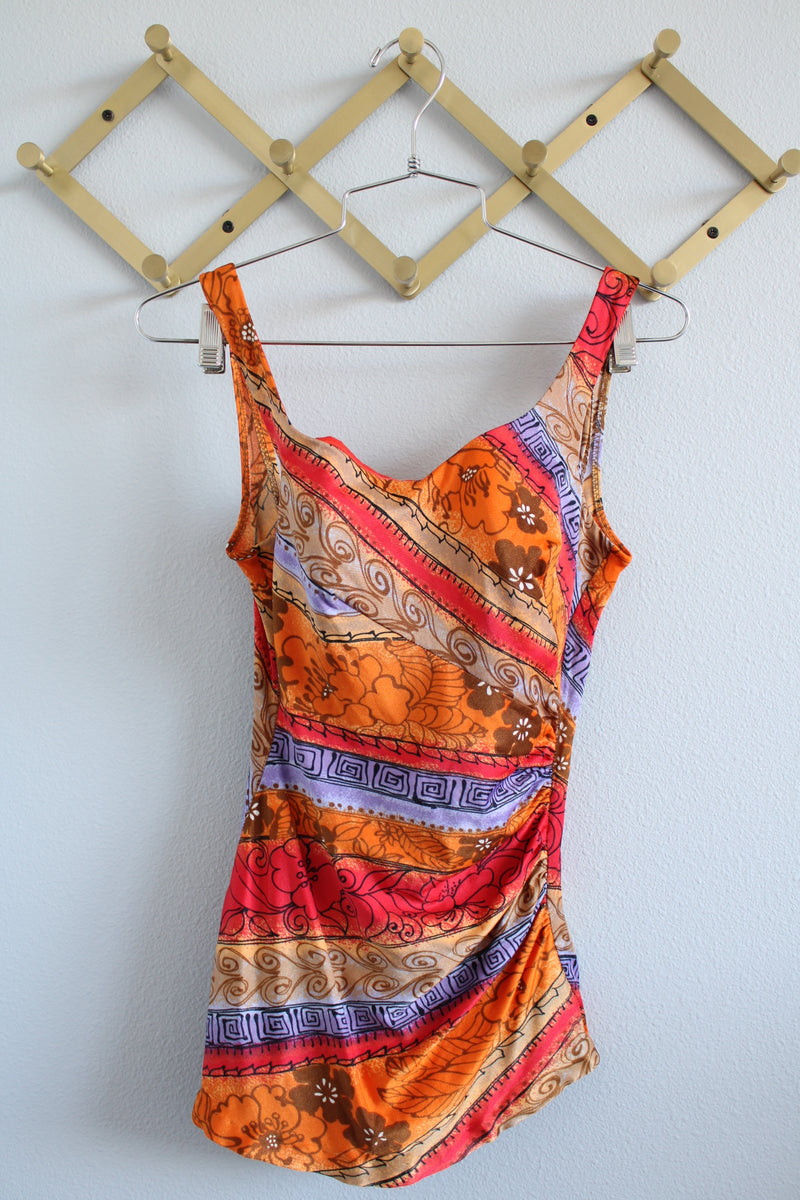 Women's vintage 1970's Sirena label sleeveless one piece swimsuit with all over orange, red, and purple print.