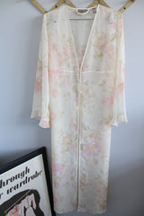 Women's vintage 1980's Valerie Stevens label long sleeve cream sheer lingerie robe with pink floral print, ruffle sleeves, and a tree button closure. 