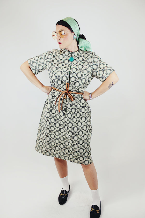short sleeve green and cream printed knee length dress with front zipper and tie belt vintage 1970's