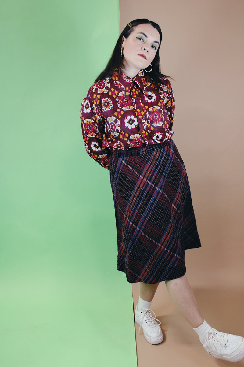 Women's vintage 1990's Take 1 label knee length a-line shaped skirt with elastic waistband in a multicolored plaid print in a polyester acrylic blend material.