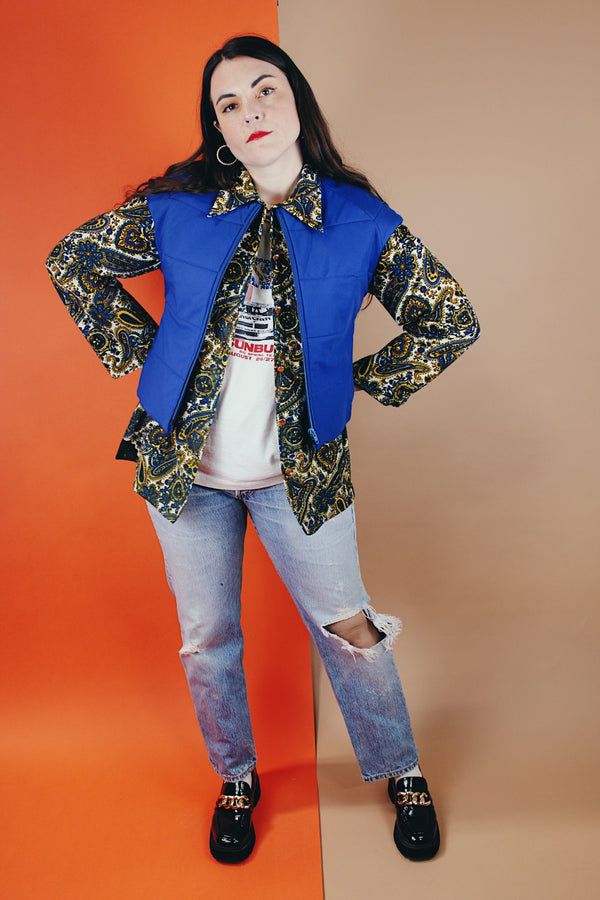 Women's vintage medium 1980's SKYR by Hertha Amen label sleeveless capped sleeved short length zip up bright blue Nylon ski vest with red and green stripes on the sides.